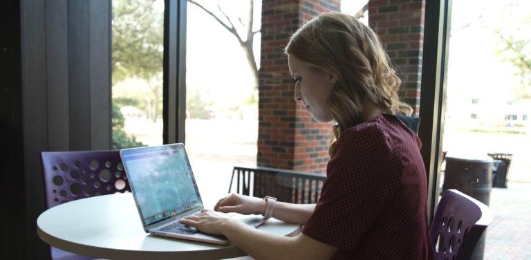 HSU的学生正在用她的笔记本电脑工作