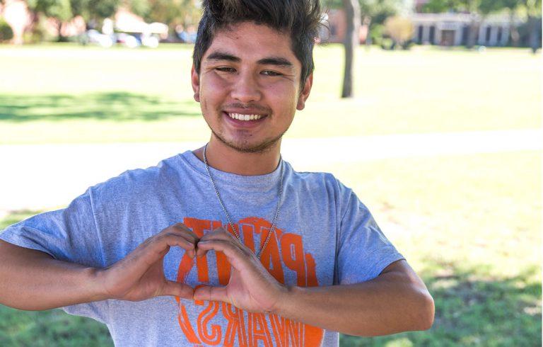 一名学生用手做了一个心形来感谢捐赠者.